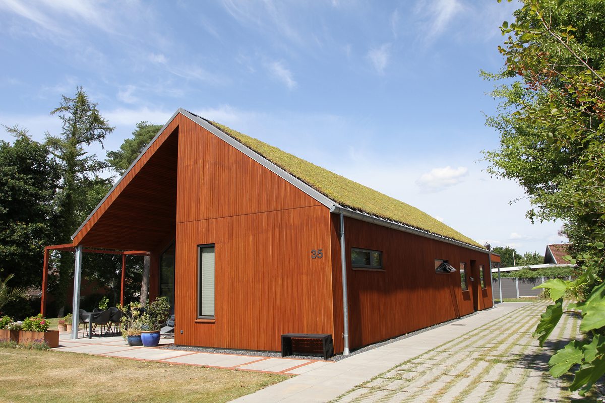 Nyopført hus med facade i træ og cortenstål samt grønt sedumtag